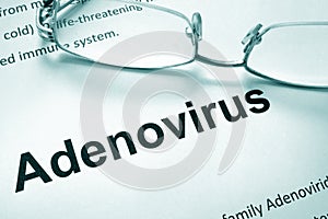 Paper with word adenovirus and glasses. photo