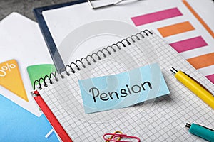 Paper with word PENSION and stationery on notebook page