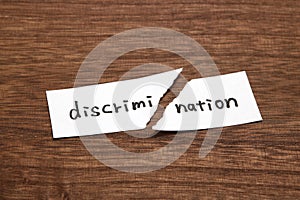 The paper written as discrimination is torn on wood. Concept of abolition of discrimination.