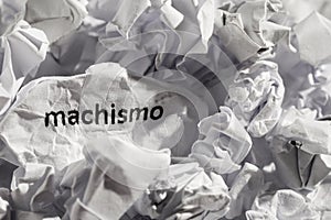 Paper written machismo, portuguese and spanish word for chauvism. Concept of old and abandoned idea or practice. photo