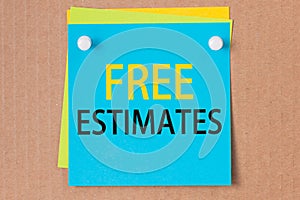 On a paperboard background - a light blue square sticker with the text free estimates, business concept