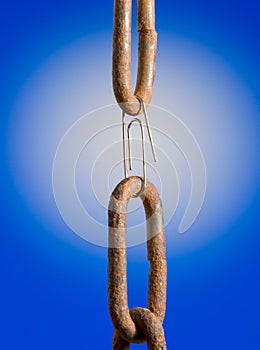 Paperclip as chain link over blue background