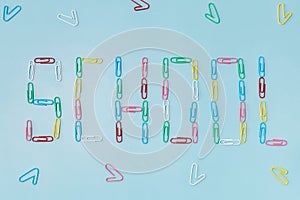 Paperclip on blue background, lettering that Back to school concept. Precautions for COVID-19. Top view flat lay background.