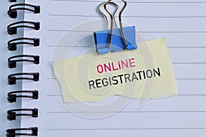 Paperclip and torn paper written with text ONLINE REGISTRATION