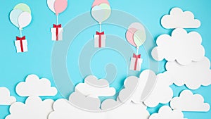Papercut balloons and Gift Box floating in blue sky with clouds. Happy Bithday, Merry Christmas festive poster. Greeting card