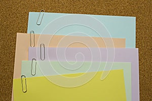 Papers with paper clip attached on the brown board