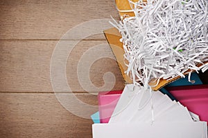 Papers shreds, Paper Trimmings Waste from shredder machine in  box on wooden background ,Thai alphabets printed on some scrap