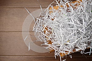 Papers shreds, Paper Trimmings Waste from shredder machine in  box on wooden background photo