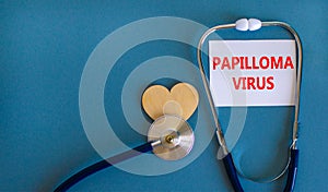 Papilloma virus symbol. White card with words Papilloma virus, beautiful blue background, wooden heart and stethoscope. Medical