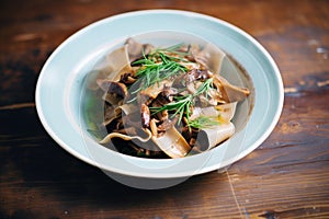 pappardelle with wild mushrooms on an earthenware plate