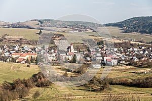 Obec Papradno s menšími kopcami Javorníkov v pozadí na Slovensku počas pekného jesenného dňa