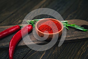 Paprika, chili peppers and rosemary on a wooden board