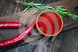 Paprika, chili peppers and rosemary on a wooden board