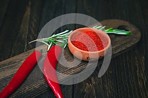 Paprika, chili peppers and rosemary on a wooden board