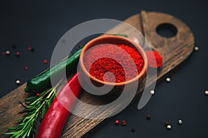 Paprika, chili peppers and rosemary on a wooden board