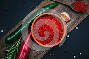 Paprika, chili peppers and rosemary on a wooden board