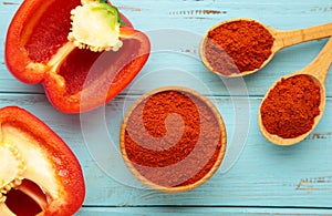 Paprika powder with fresh red pepper on blue background
