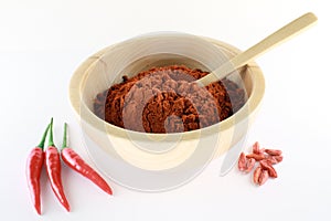 Paprika powder in a wooden bowl with chili