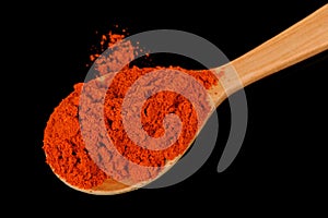 Paprika in Wooden Spoon on Black Background