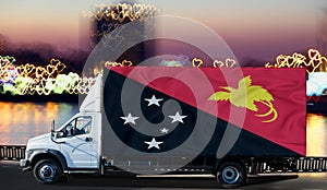 Papua New Guinea flag on the side of a white van against the backdrop of a blurred city and river. Logistics concept