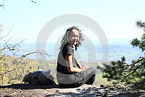 Papuan girl sitting on rock in Czech Switzerland