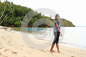Papuan girl walking on beach