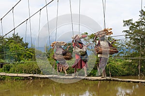 Papuan women crossing bridge, Wamena, Papua