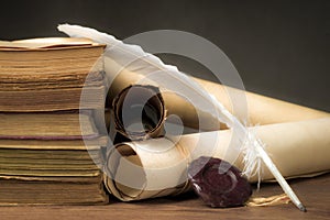 Papyrus scrolls on a table top with books and pen