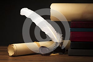 Papyrus scrolls on a table top with books, pen and inkwell