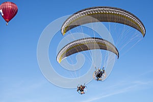 Para gliders with engine flying in the high blue sky