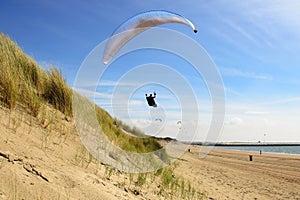 Para gliding above the dunes and coastline