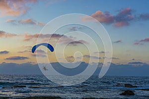 Para motor glider flying over the sea