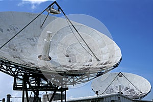 Parabolic satellite dish receiver over blue sky