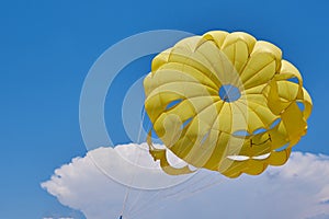 Dome of the yellow parachute on the blue sky.