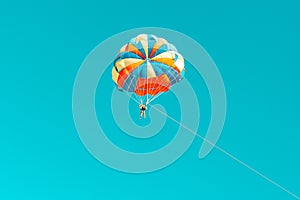 Parachute parasailing of tourists on a sandy beach Sunny weather against the background of clear sea and ocean.The wind blows up