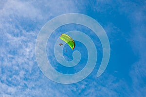 parachute in the sky. A tandem of two parachutists flies on a parachute in the blue sky