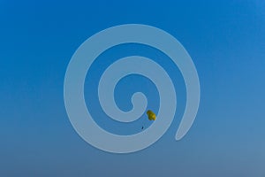 Parachutes flying in the distance over the blue sky