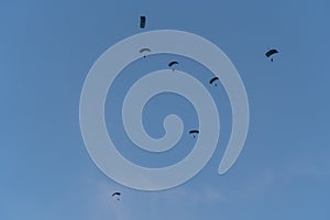 Parachuting exercises of soldiers in parachuting on a blue sky background
