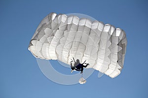 Parachutist on blue sky photo