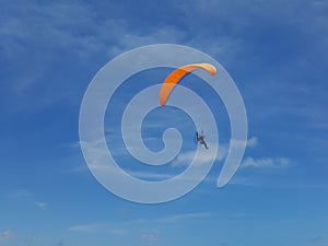 Parachutist descending with a blue sky background