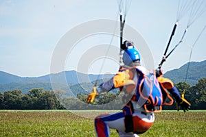 Parachutist jumped from an air plane uses a parachute to land.