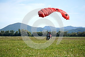 Parachutist jumped from an airplane uses a parachute to land.