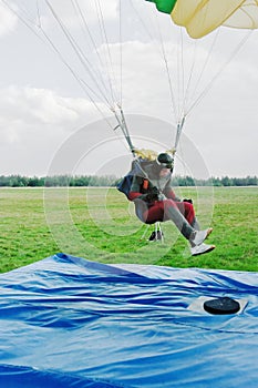 The parachutist lands on a floor-mat with a target