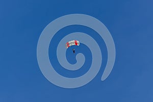 Parachutist silhouette against clear blue sky. Sport, hobby background