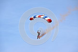 Parachutist / sky diver coming down to earth