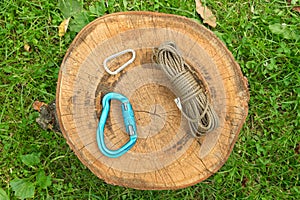 paracord and carabiners in nature on a stump