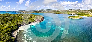 Paradise beach and bay in Carribean archipelago in Antilles with transparent turquoise sea water and coral reefs. Aerial drone photo