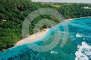 Paradise beach with blue tropical ocean and waves in Bali. Aerial view