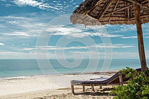 Paradise beach with sunbeds under umbrella