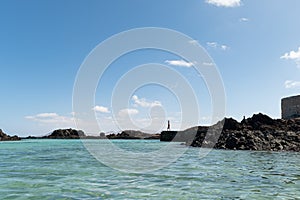 Paradise island of Lobos, Canary Islands, Spain. In the background, a person about to jump into the water from a small wooden